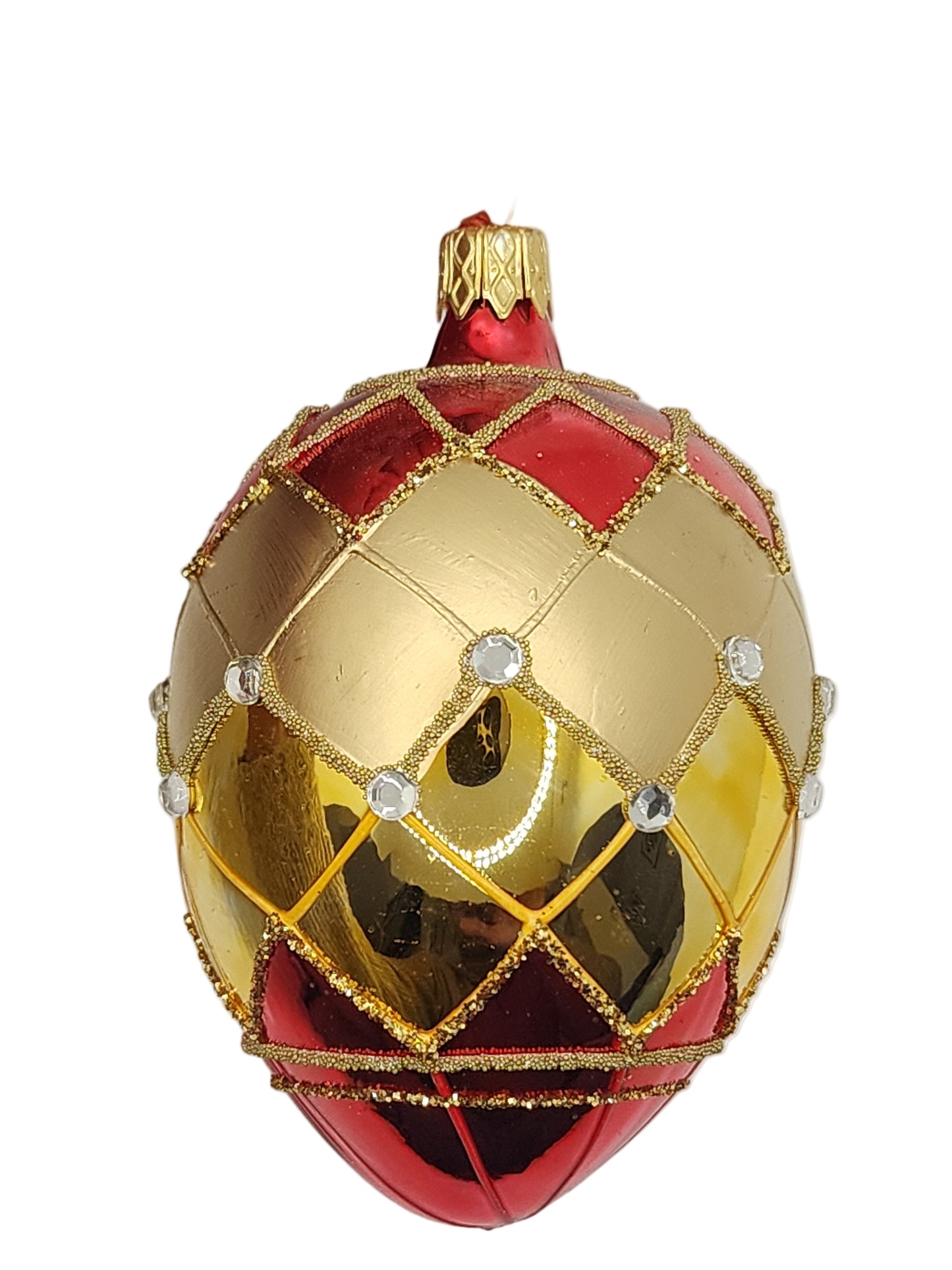 Decorative gold and red egg with gemstone accents against a neutral background