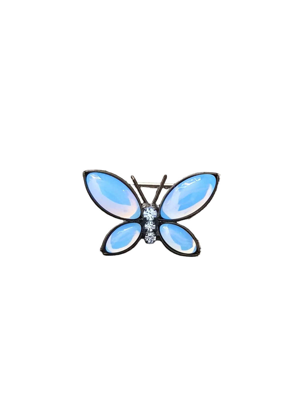 A butterfly-shaped brooch with light blue iridescent enamel wings and a small cluster of clear rhinestones at the center.