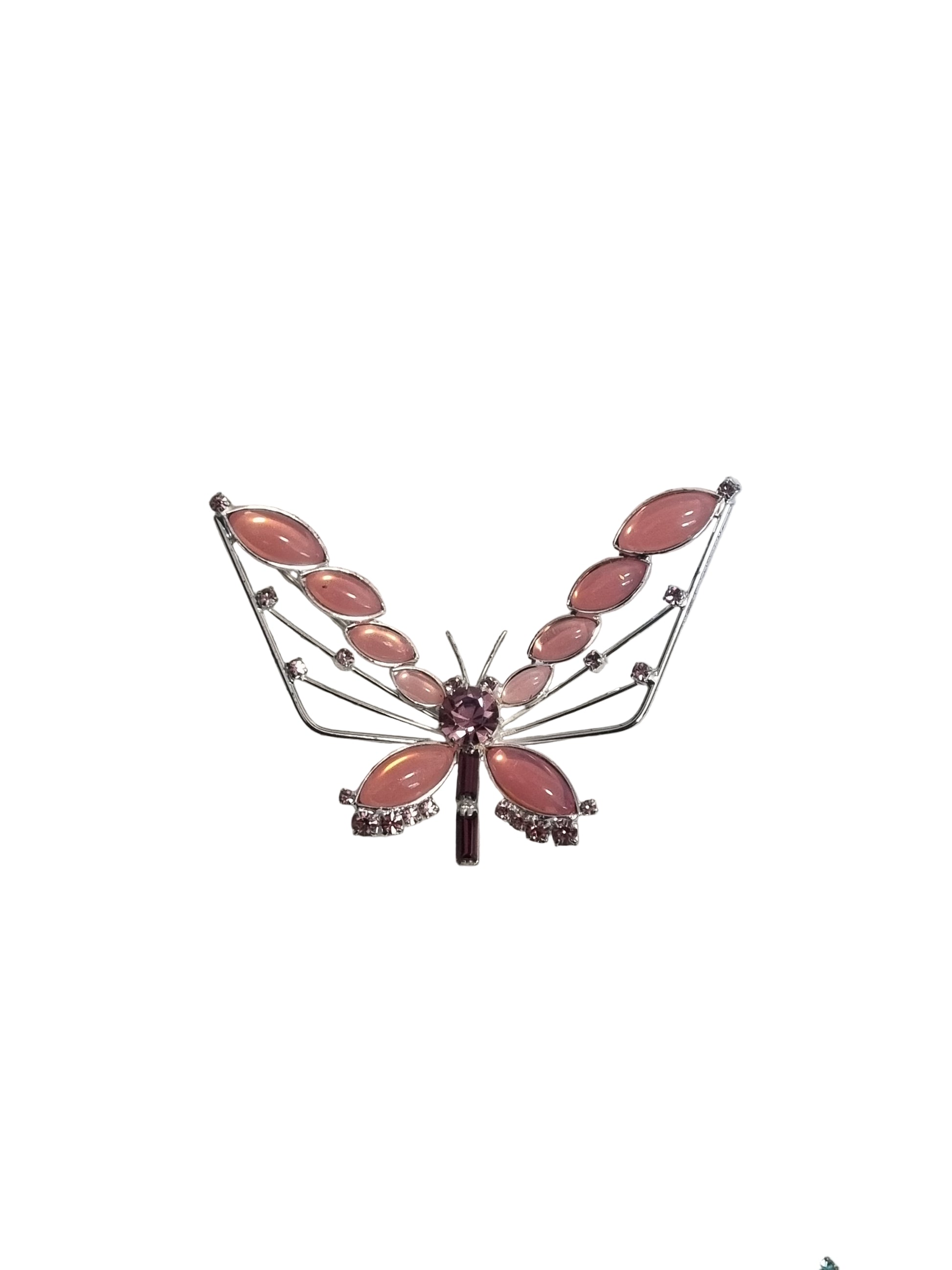 Decorative brooch with pink gemstones on a textured gray surface