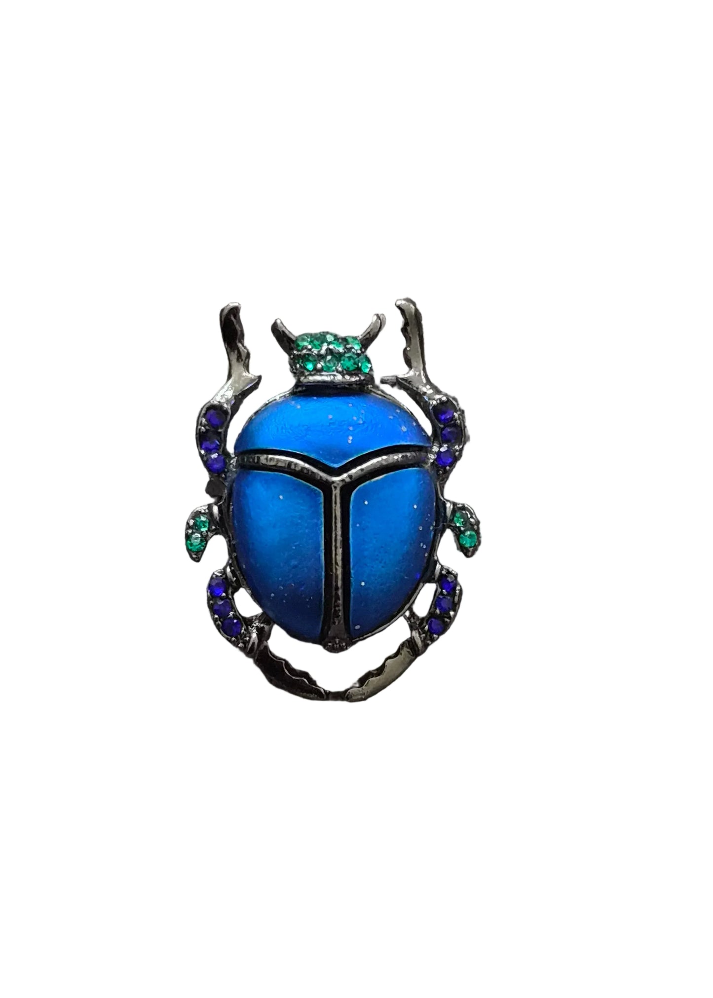 A beetle-shaped brooch with a vibrant blue enamel body, silver-toned metal borders, and small green and blue gemstone accents.
