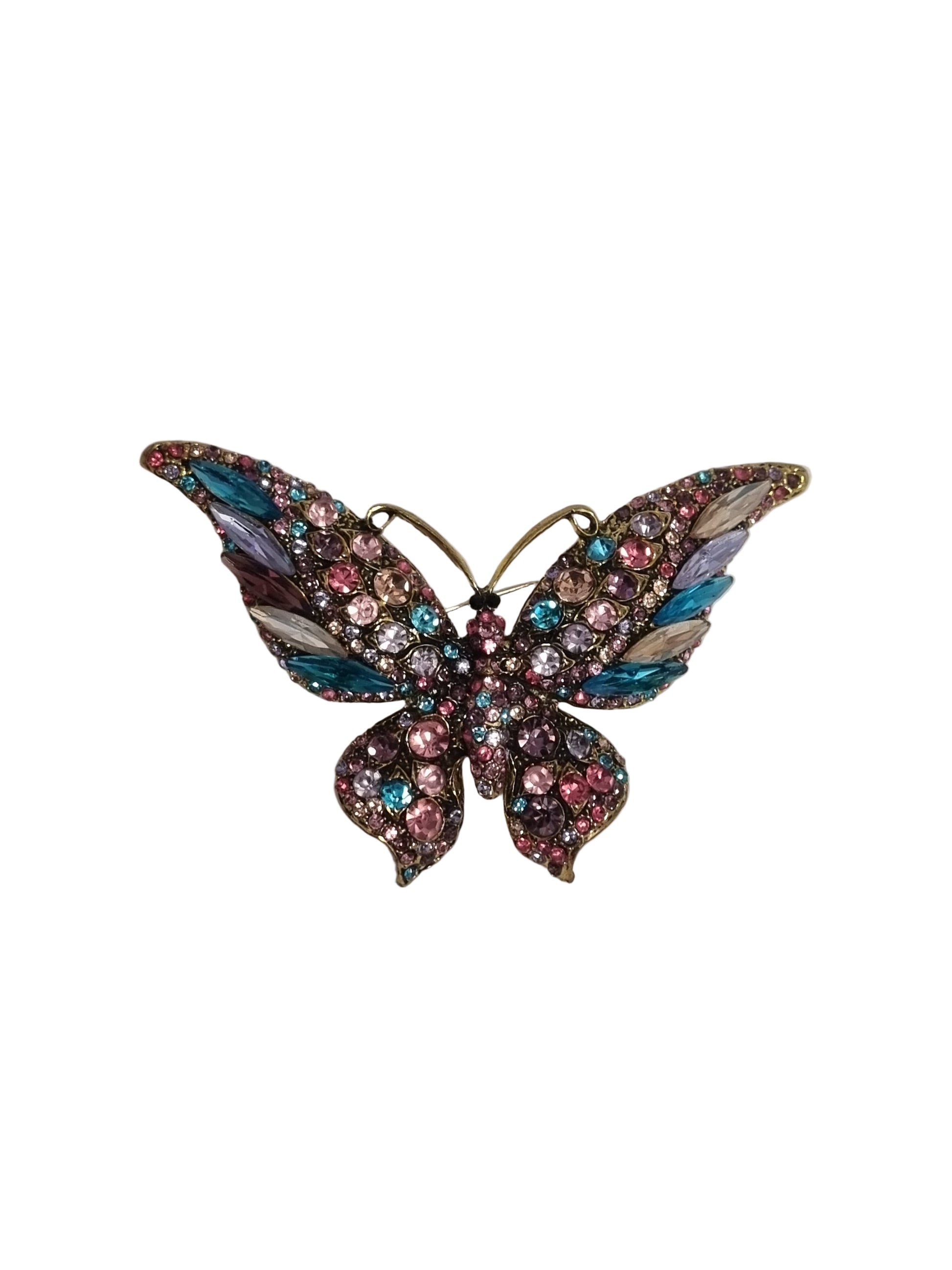 Butterfly-shaped brooch with gemstones on a white fabric background